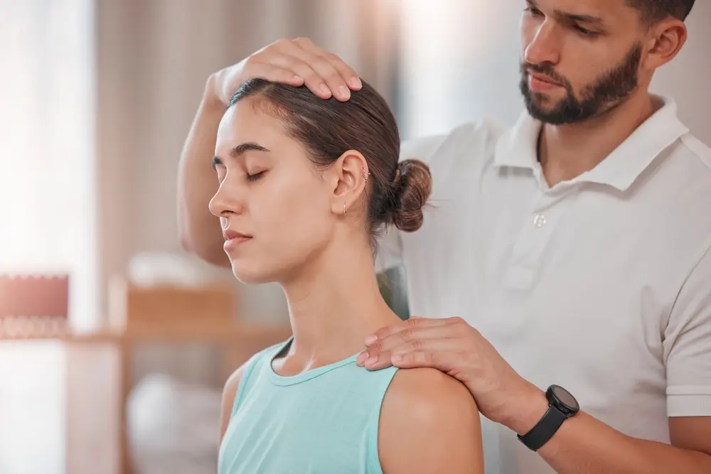 Woman receiving neck physiotherapy and consultation from a therapist for personalized car accident rehabilitation plan