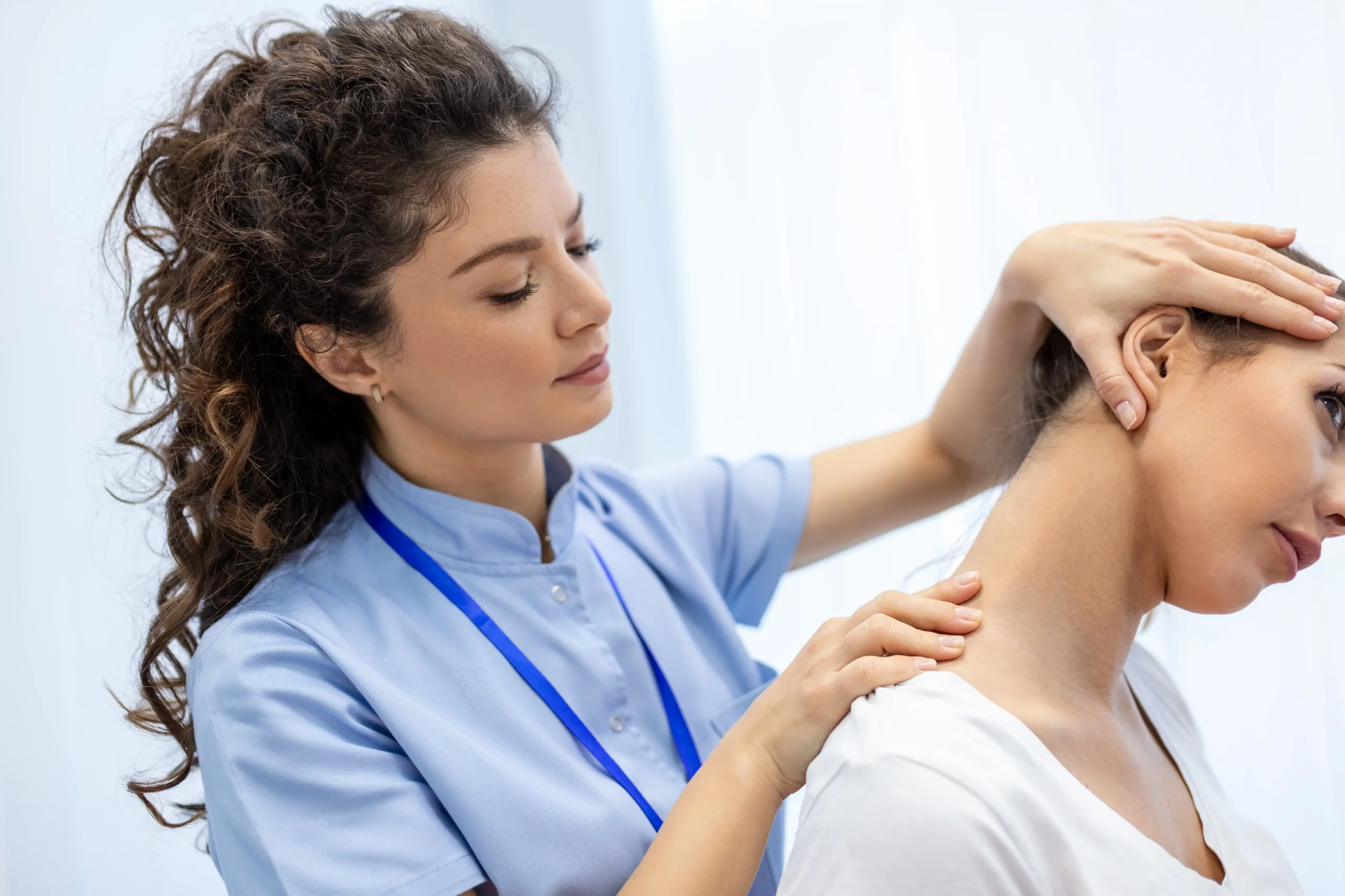 Physiotherapist performing hands-on neck treatment for office-related neck pain in a clinic setting.
